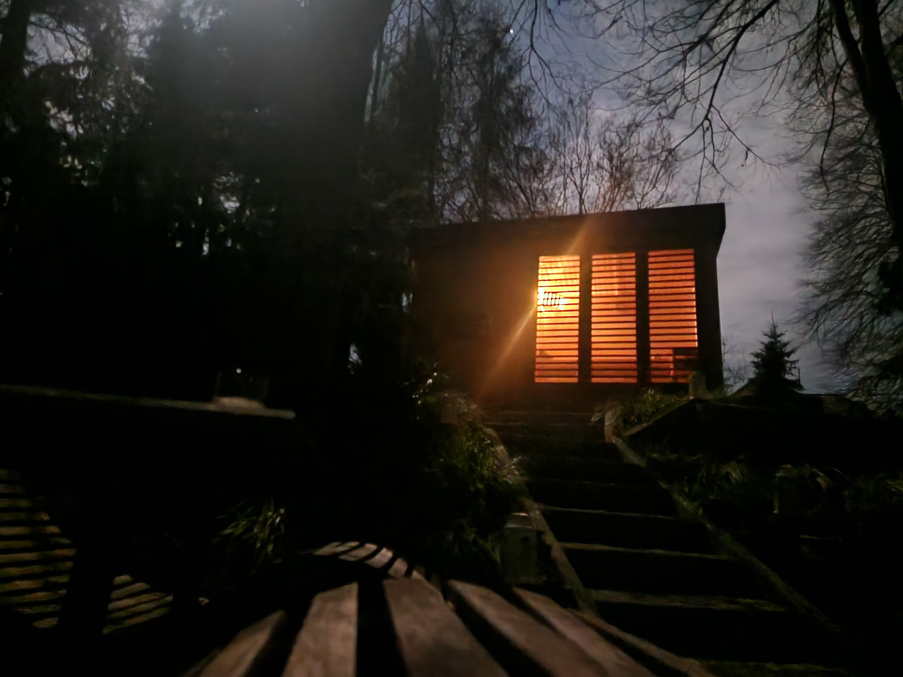 Sauna nocą, ciepłe światło za żaluzjami, schody prowadzące w górę